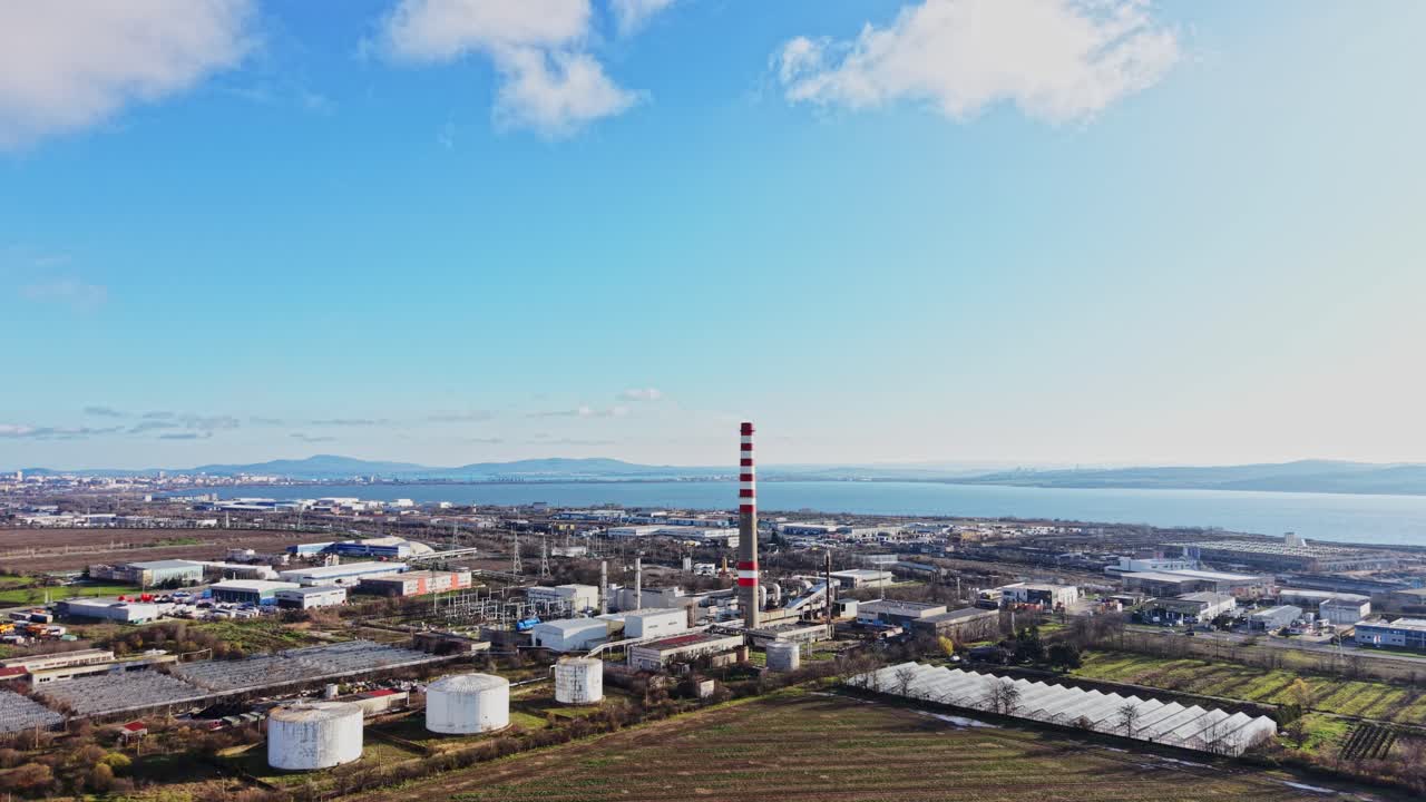 澄み切った空に、工場と煙突がある水辺の工業地帯