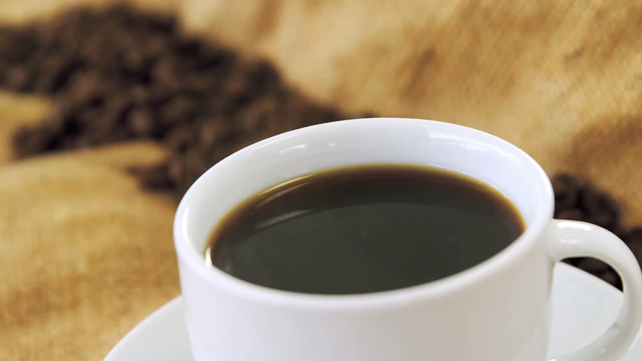 taza de café con granos de café en el saco