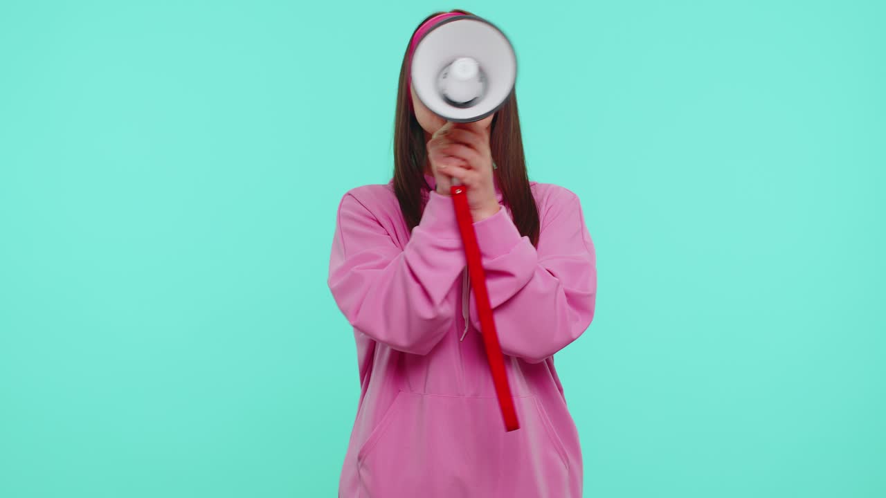 십대 소녀는 메가폰으로 비명을 지르며 라우드 스피커에서 할인 판매를 발표하고 광고를 발표합니다.