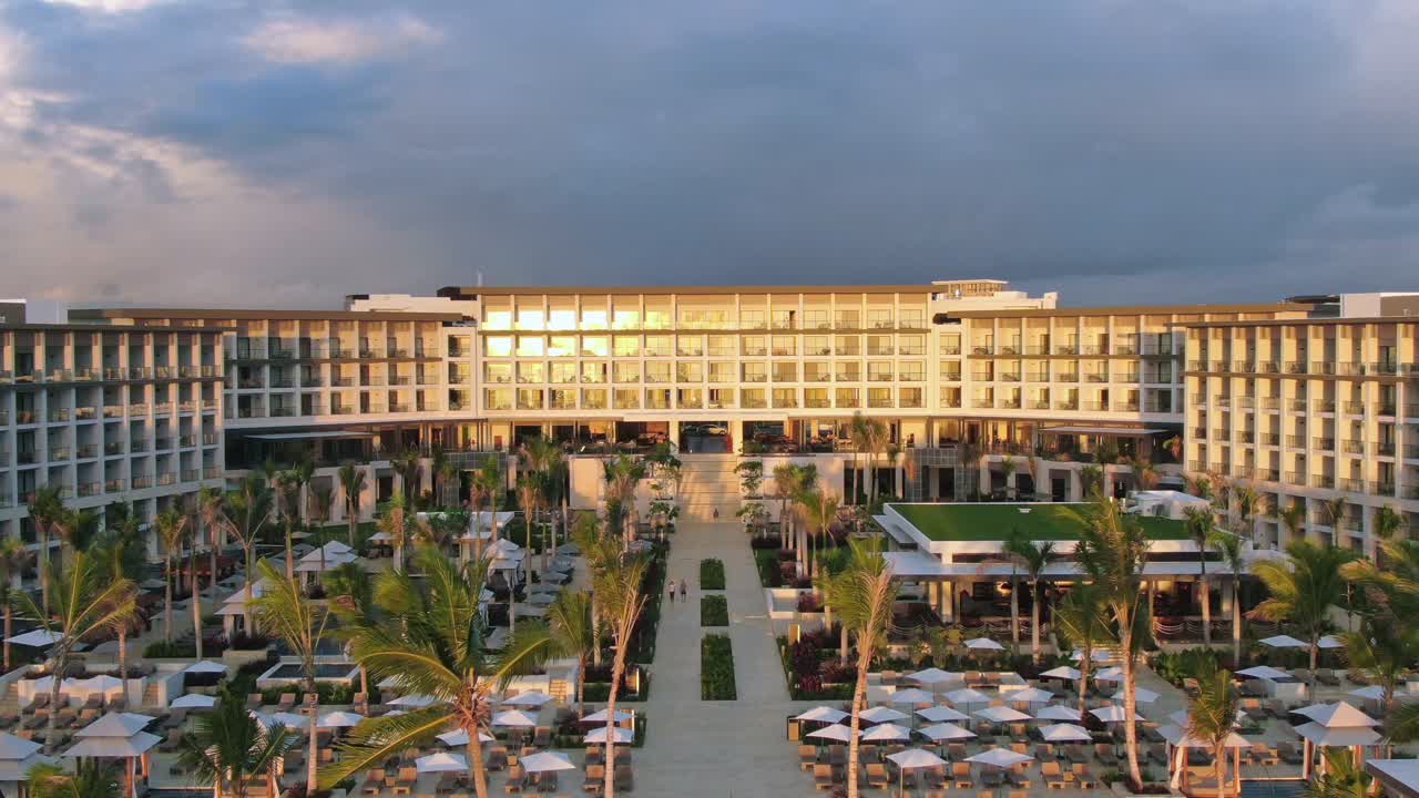 Resort tropicale all'alba e al tramonto, hotel con piscina, palme e bar sotto una luce dorata, destinazione per vacanze ai Caraibi, fuga di luna di miele nella Repubblica Dominicana, vista aerea