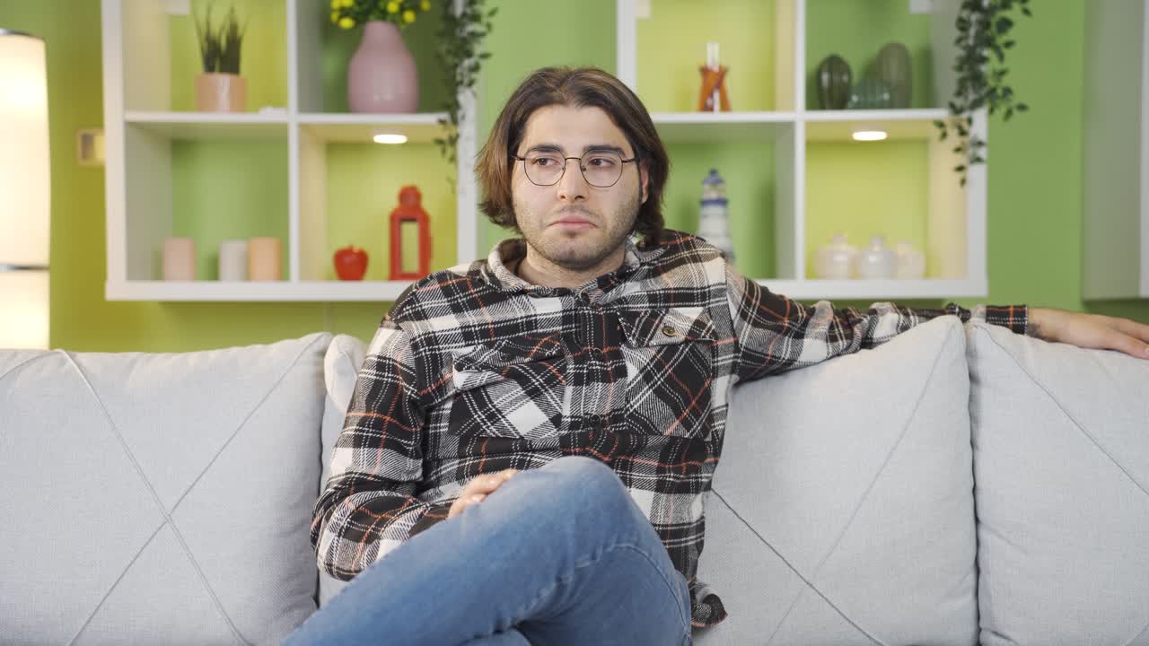 un joven solo en casa pensando.