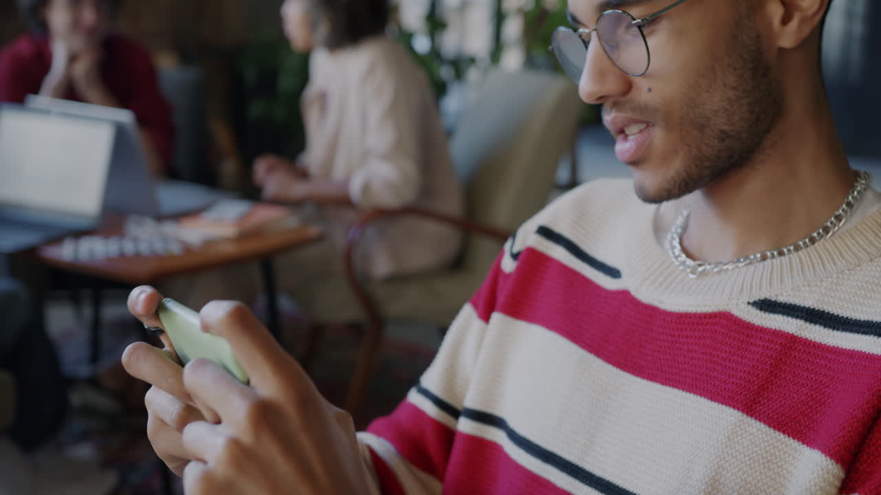 Man playing game on smartphone in a cafe
