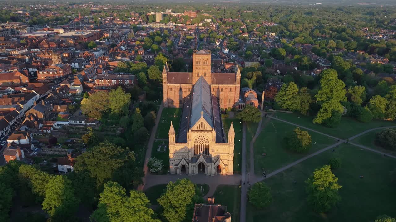A cinematic drone pullback with tilt-up motion reveals St Albans Cathedral rising above the city and surrounding landscape, showcasing its gothic architecture and urban scenery