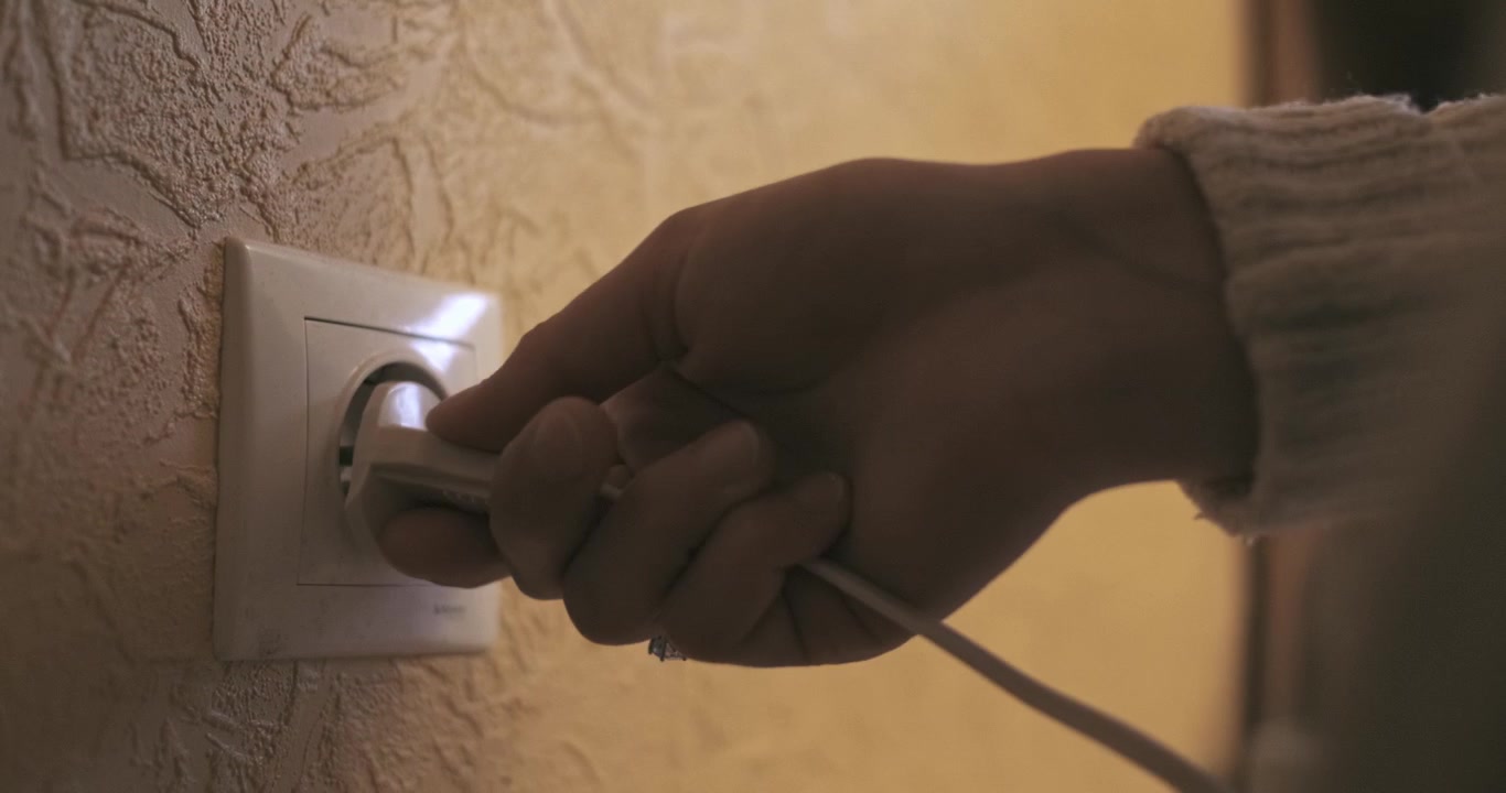 Closeup Of A Power Cord Plugged Into A Electrical Outlet.