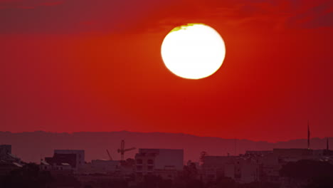 Amanecer-En-Un-Cielo-Rojo-Brillante-Detrás-De-Un-Pueblo-Envuelto-En-La-Oscuridad