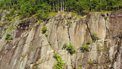 aerial footage left orbit around lone climber on cliff in maine