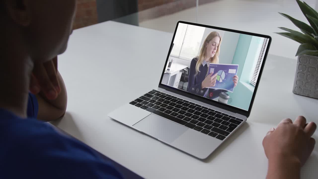 Mid section of african american woman having a video call with female colleague on laptop at office