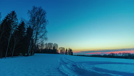 golden orange sun setting on horizon over winter snow covered landscape