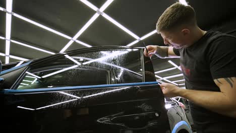 man covering car with vinyl polyurethane tape. films for the car. sticker protective film on the car