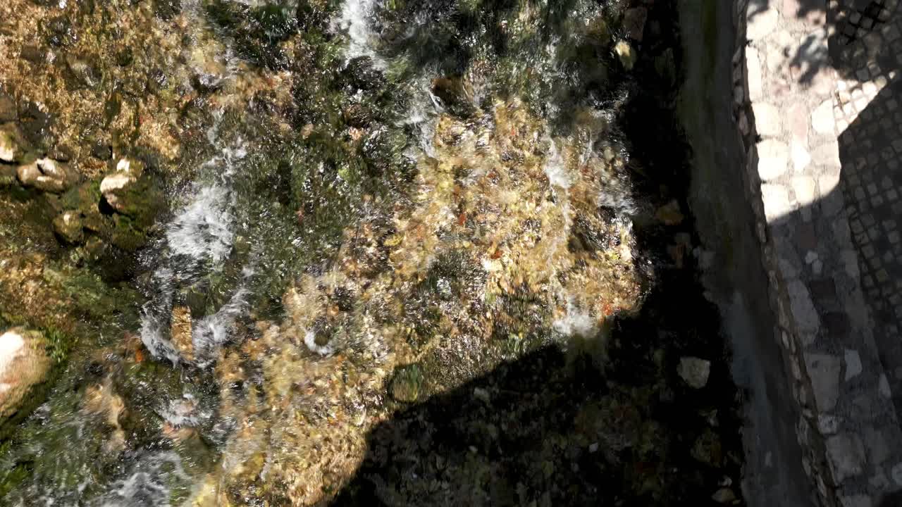 воздушный полет над неглубокой текущей рекой в небольшой деревне в италии