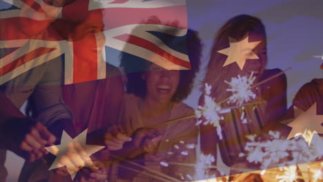 composite video of australia flag over group of diverse friends celebrating with sparklers at beach