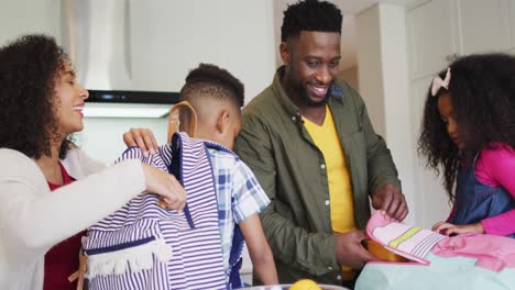 Happy-african-american-parent-preparing-children-for-school