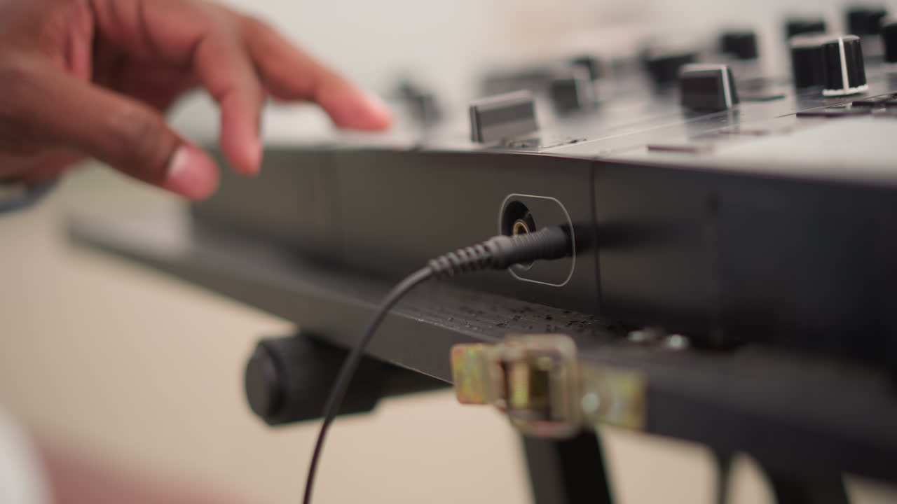 musician hands adjusting mixer cable closeup, rooftop soundcheck at sunset with striped sleeve, focused tuning of input and knobs, polished gear on portable stand, calm crowdready atmosphere