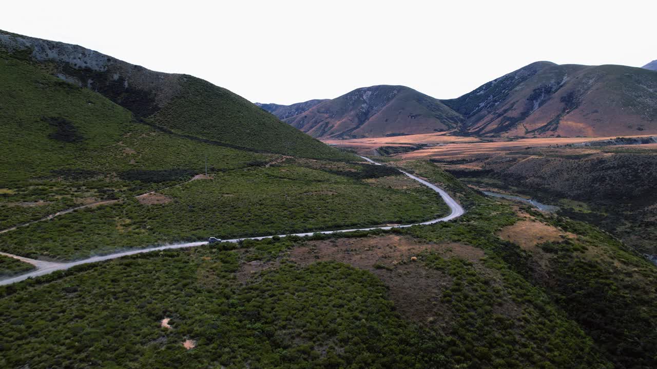 Aerial view following a car driving at Mount Cheesman in cloudy New Zealand