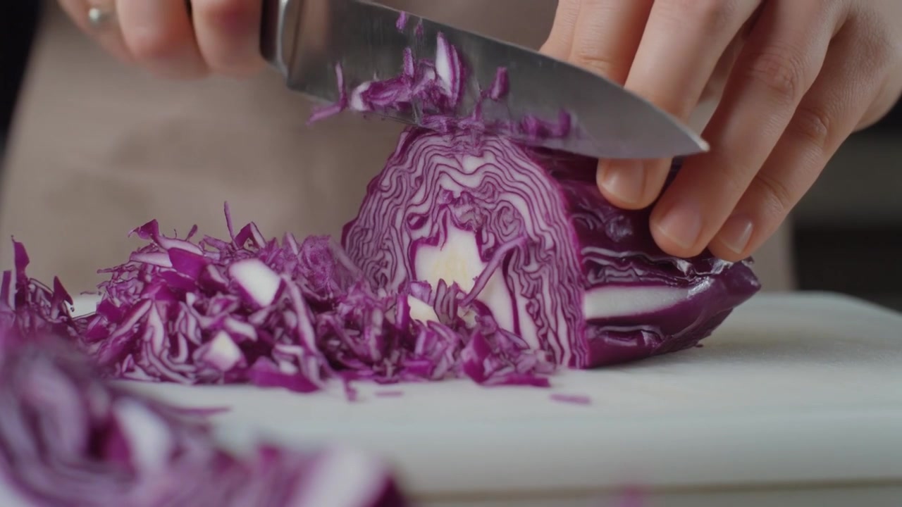 Person Slicing Fresh Red Cabbage on a Cutting Board