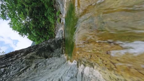 Vertical-video-climbing-a-tropical-waterfall-in-las-yayitas-rainforest,-fpv