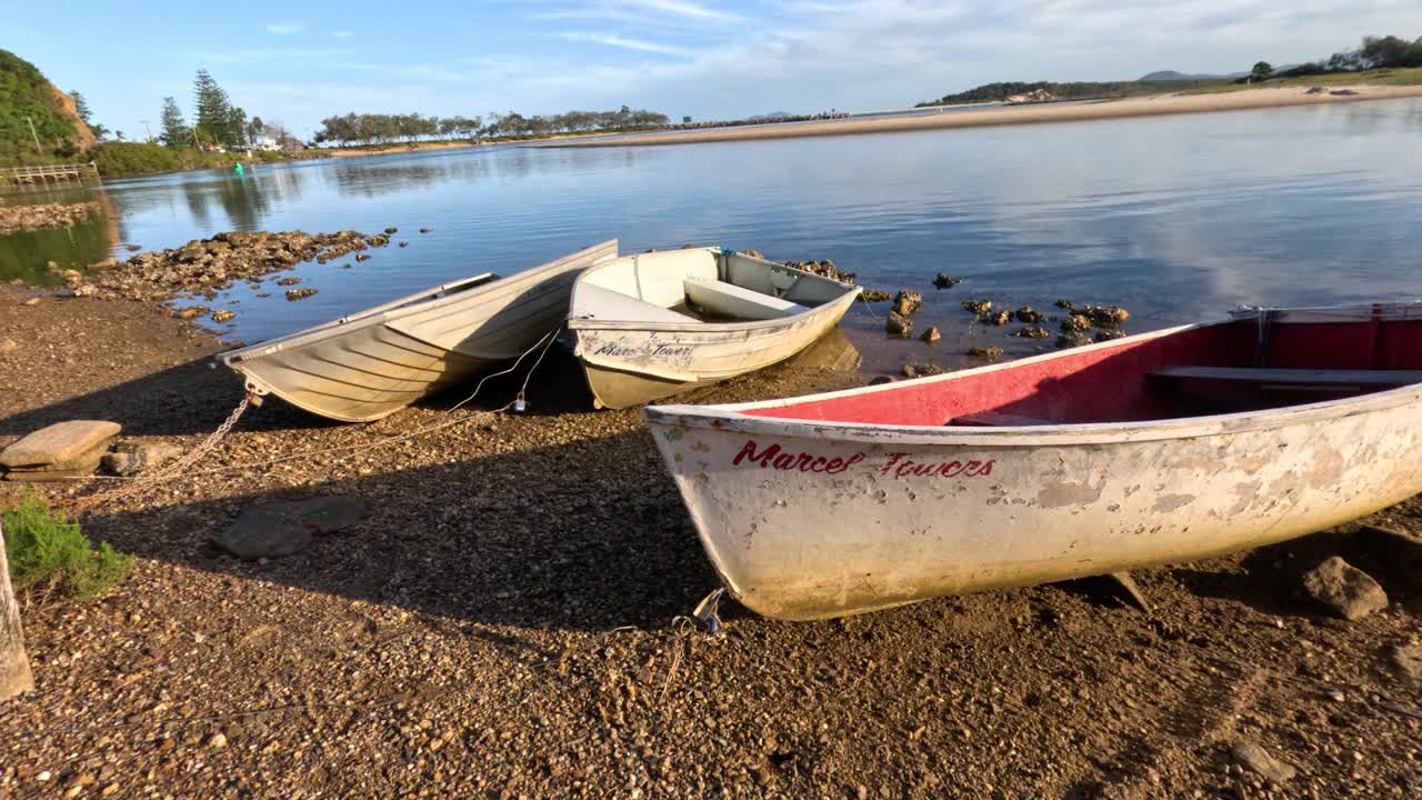 lago tranquilo con barcos en la orilla al atardecer