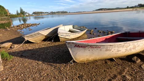 calm lake with boats on shore at sunset