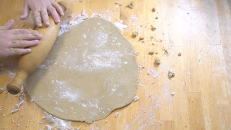 la chica despliega la masa sin gluten para la pizza o las galletas. cocinando juntos.