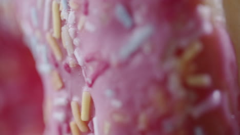 extreme macro shot of a pink donut spinning vertically