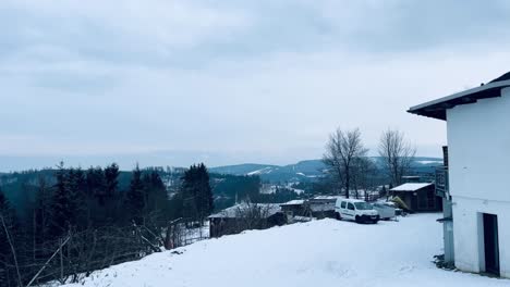 Snowy-landscape-with-mountains-in-the-background-and-wooden-fence-on-the-right