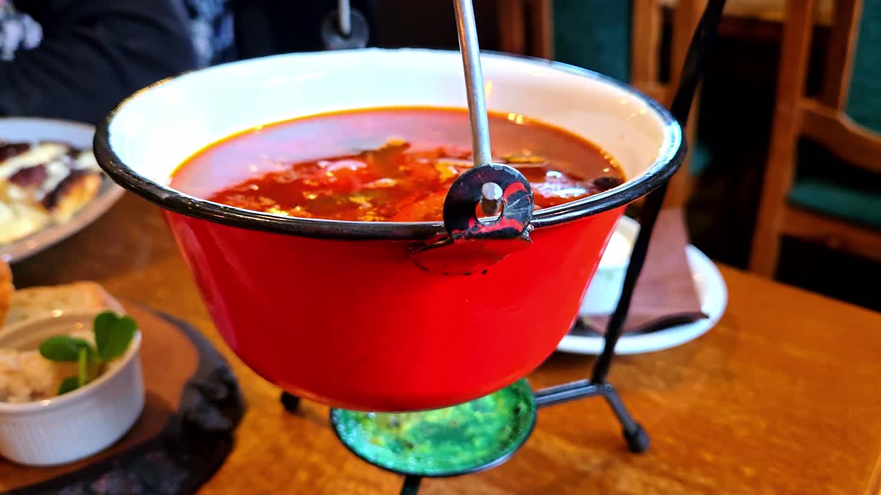 Zuppa calda servita in pentola riscaldata su fiamma, che esalta comfort e gusto all'interno