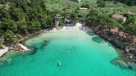 Movimiento-Cinematográfico-Lento-De-Drones-Que-Revela-La-Playa-Glifoneri-Con-Arena-Blanca,-Agua-Clara-Y-Vegetación-Exuberante,-Isla-De-Thassos,-Grecia,-Europa