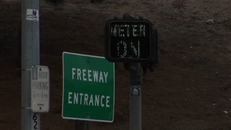 a neon sign blinks next to a freeway entrance