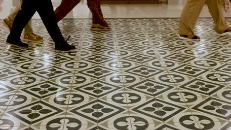 feet moving across patterned tiles in bangkok