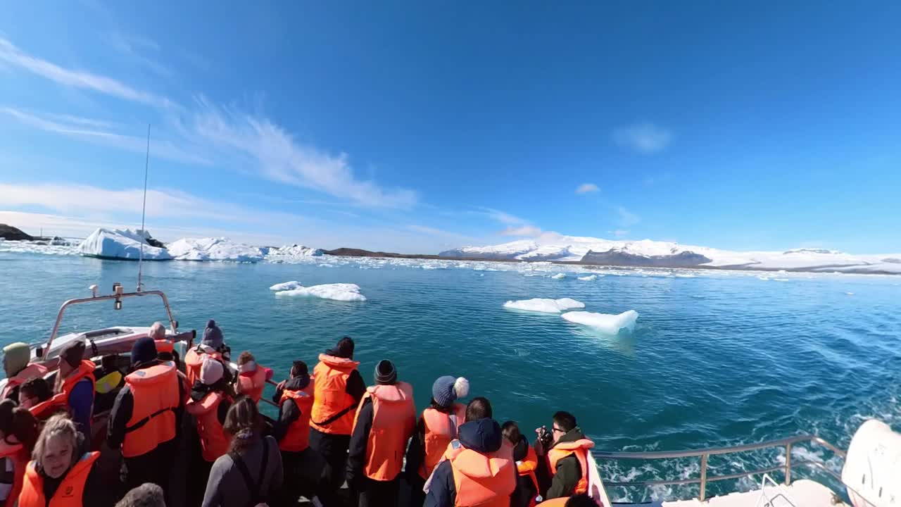 Observers are met with the serene magnificence of Iceland's wintry ocean, encompassed by snow-clad peaks and an ever-changing sky.