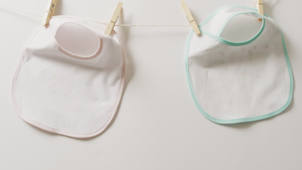 video de primer plano de dos babysitters blancos con clavijas colgando en un fondo blanco.