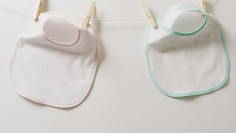 video de primer plano de dos babysitters blancos con clavijas colgando en un fondo blanco.