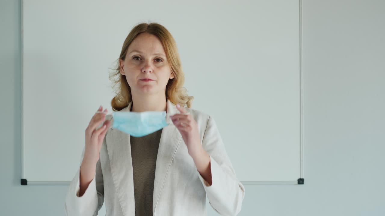 el maestro usa una máscara protectora frente al aula