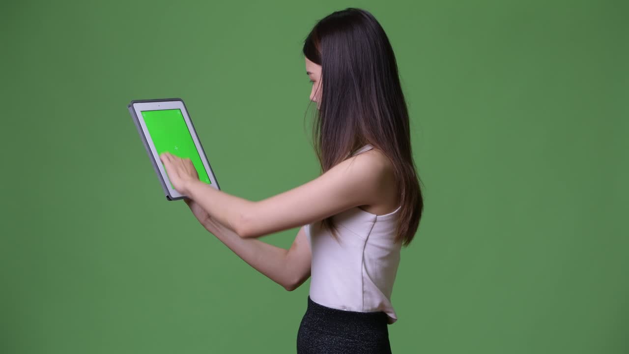 젊은 아름다운 아시아 사업가 여성이 디지털 태블릿을 보여줍니다.
