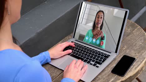 Caucasian-woman-using-laptop-on-video-call-with-female-colleague-working-from-home