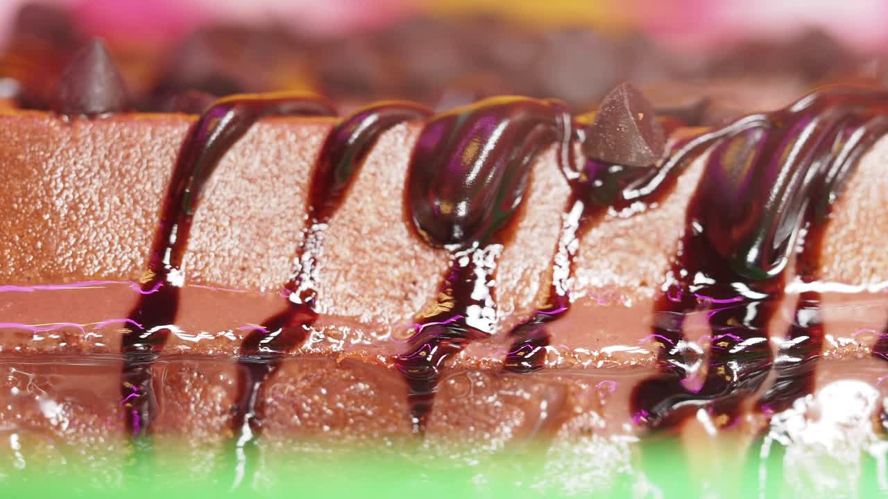 Close up of a chocolate waffle cake with chocolate syrup and chocolate chips