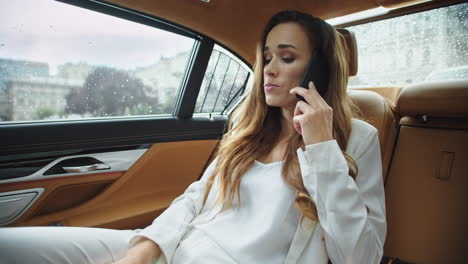 una mujer de negocios triste hablando por teléfono móvil.