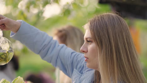 Familie-Und-Freunde,-Gartenparty-Im-Freien,-Lächelnde-Junge-Frau-Gießt-Limonade-Ein