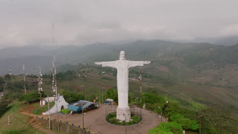 el zoom aéreo revela la estatua de cristo rey jesús en la cima de una montaña en las afueras de cali, colombia