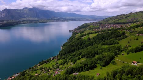 aerial take of the thunensee lake in swiss alps, nearby interlaken town