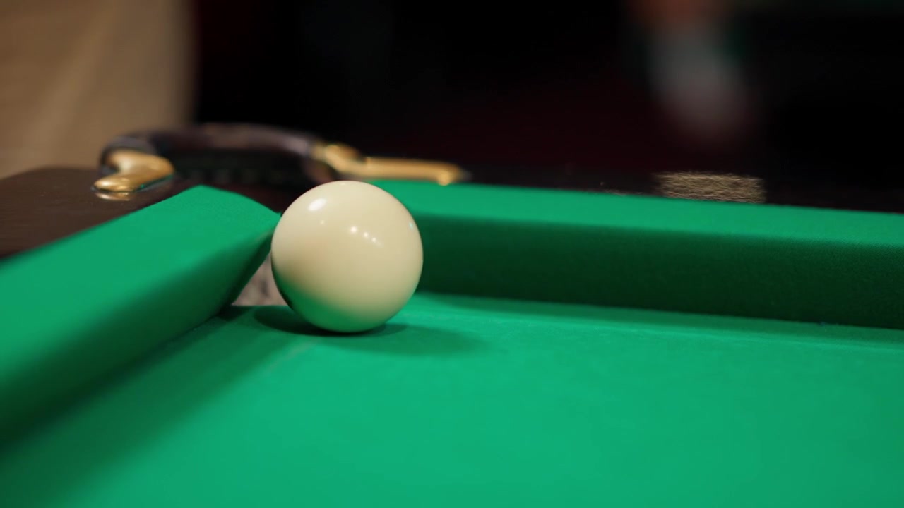 Witte bal raakt een 9-ball op een groene biljarttafel in slow motion