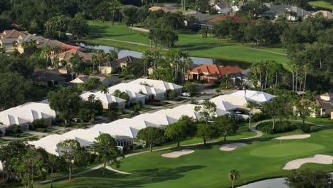 luxury houses in golf club of bradenton, florida. aerial wide shot. sunset time with palm trees and golf course