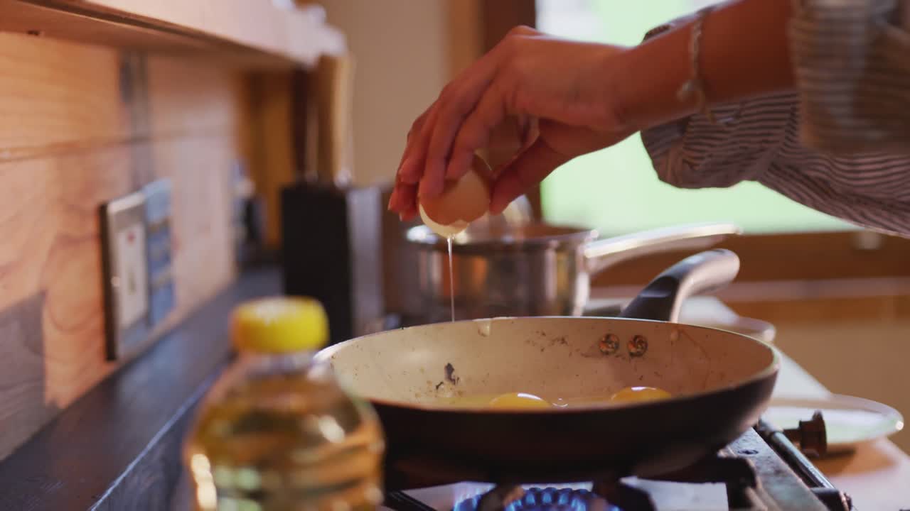 mujer de raza mixta preparando el desayuno en casa