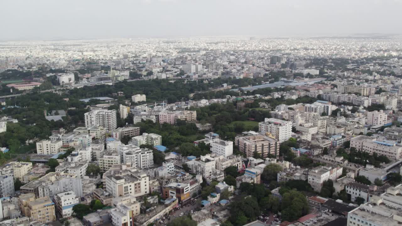 Aerial footage shows crowded mid-size apartments and Railway Station Train leaving in a city in India, the commercial area around Star hotels, and one of the city's wealthiest neighbourhoods