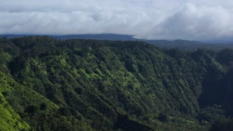 Wide-shot-of-greenery-covered-knife-edge-ridges-along-the-Northern-coast-of-Maui-with-clouds-in-the-background