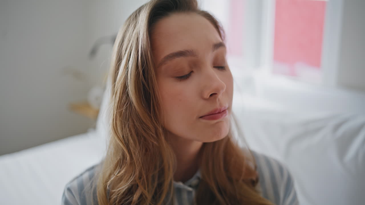 Pensive lady sitting bed early morning showing concerned expression closeup