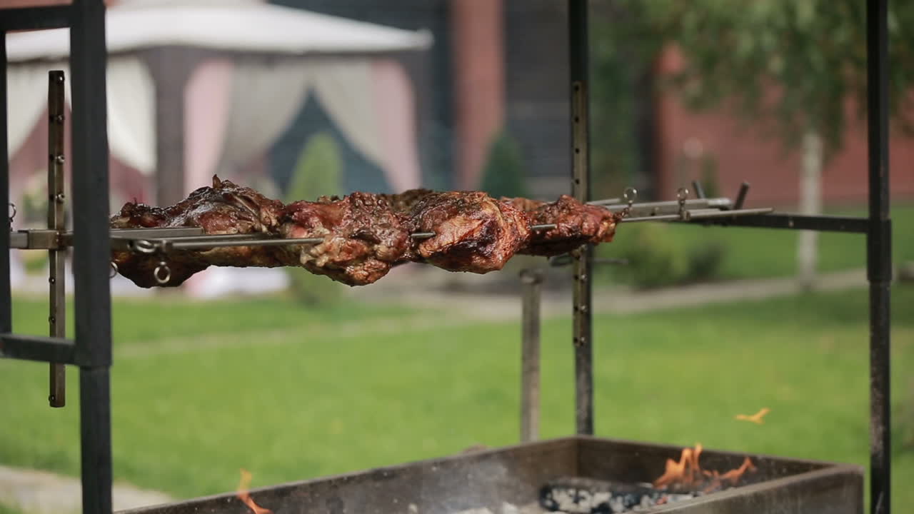 Grilled beef steak. Close up of the grilled meat in barbecue with flames