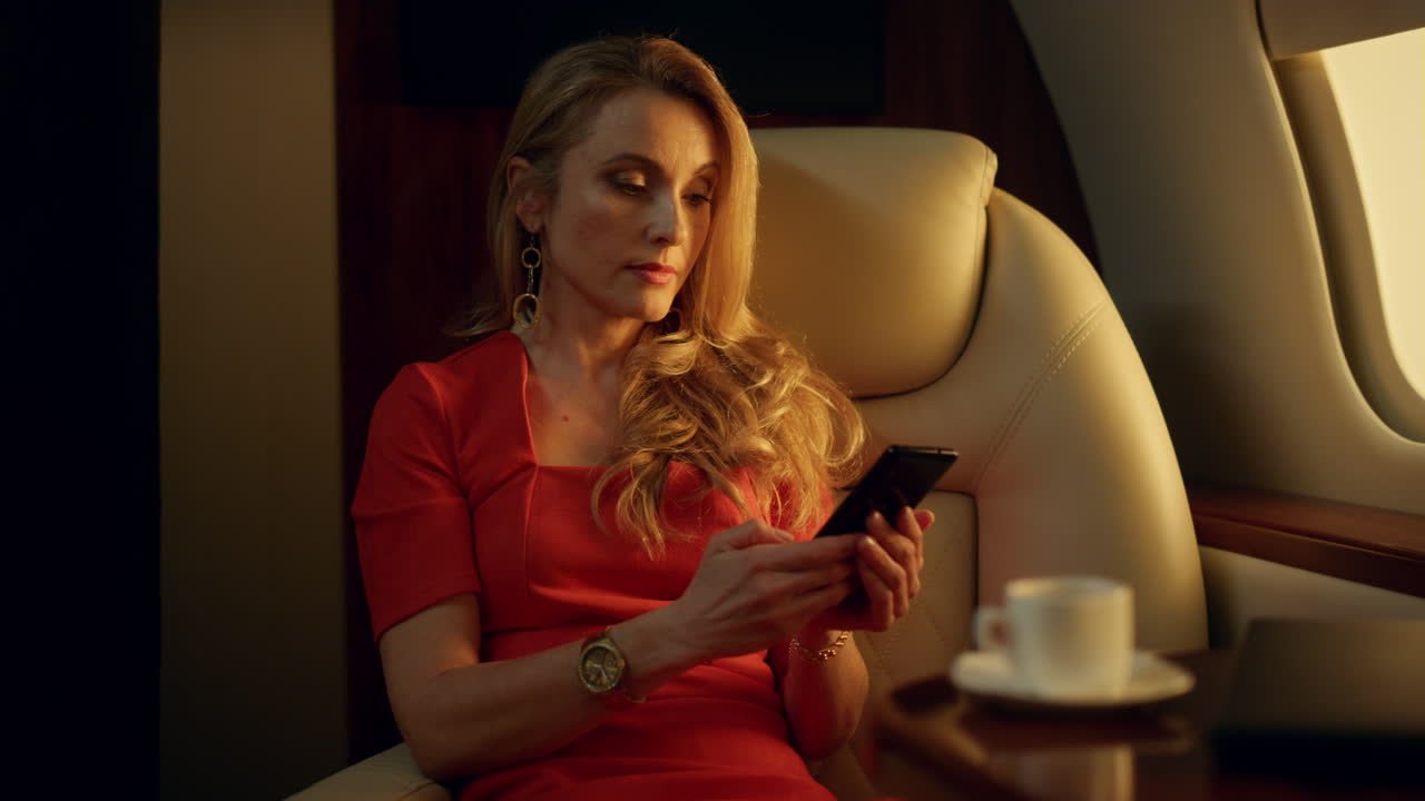 Elegante donna d'affari che invia messaggi con lo smartphone alla luce del sole. Dirigente d'azienda facoltosa.