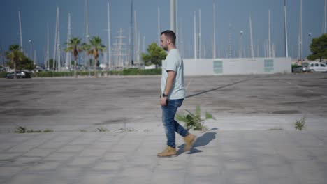 man walking with tablet in a city port area