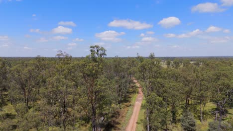 drone flies over dirt road in summer